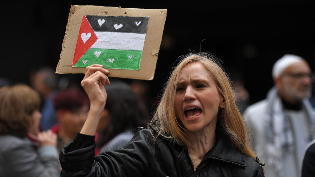 Una mujer alza la bandera palestina frente a la Embajada palestina Foto Victor Carreiras