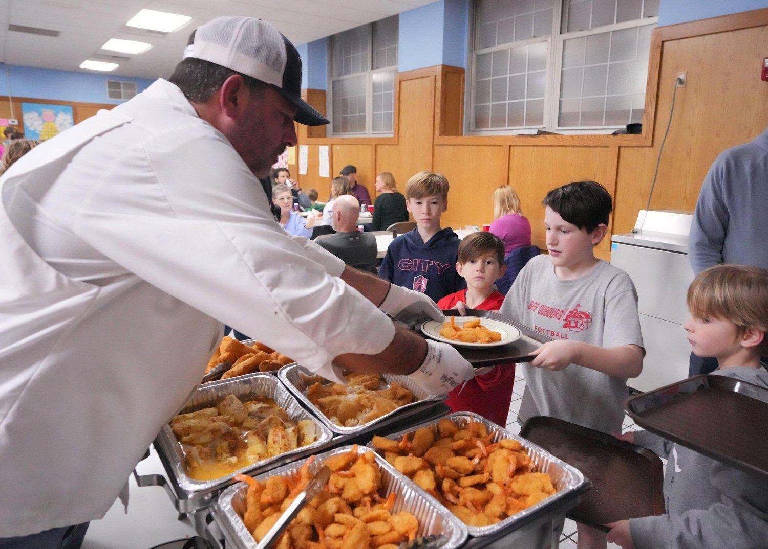 Mike Miano sirve bacalao en la iglesia St. Gabriel en St. Louis.