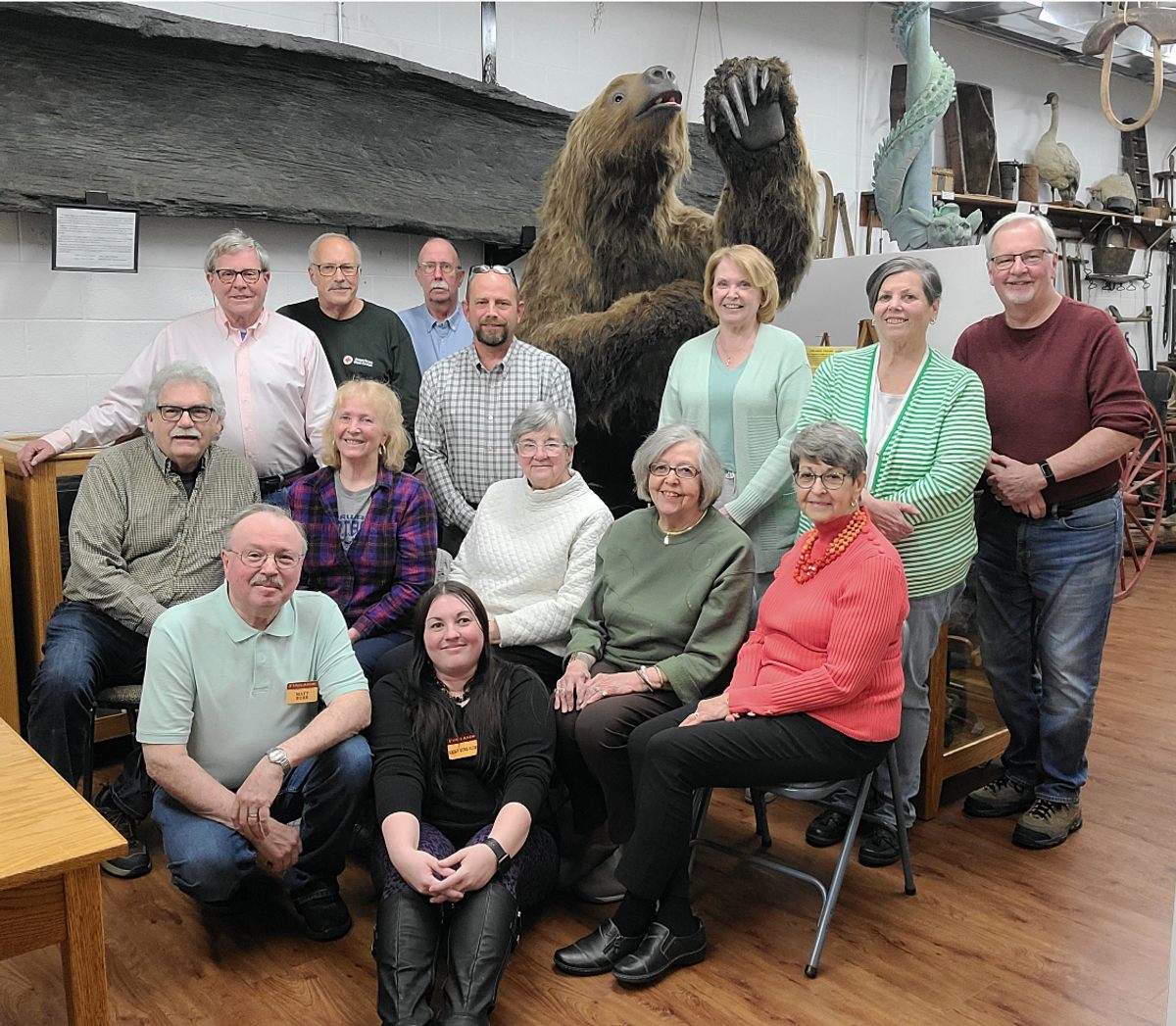 Una fotografía de los miembros de la Sociedad Histórica de Firelands posando con una réplica de casi 10 pies de un perezoso gigante encontrado cerca fue colocada en la cápsula del tiempo del eclipse de Norwalk, Ohio.