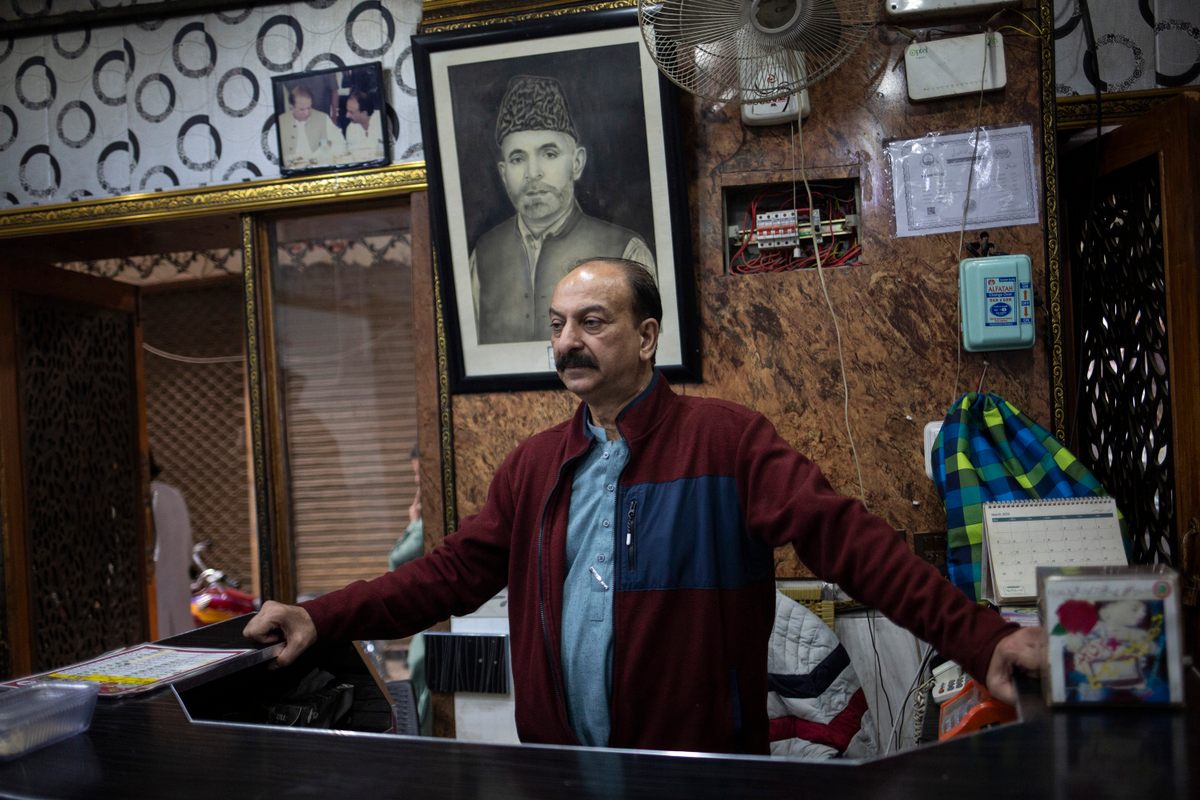 Malik Aslam frente a una fotografía de su padre, quien fundó el Hotel Dilbar en 1950.