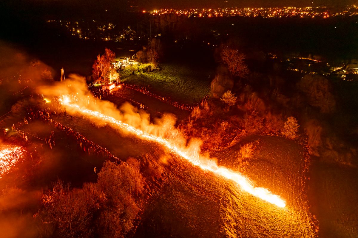 Seis ruedas de fuego caen en cascada colina abajo durante el evento, culminando con un espectáculo de fuegos artificiales.