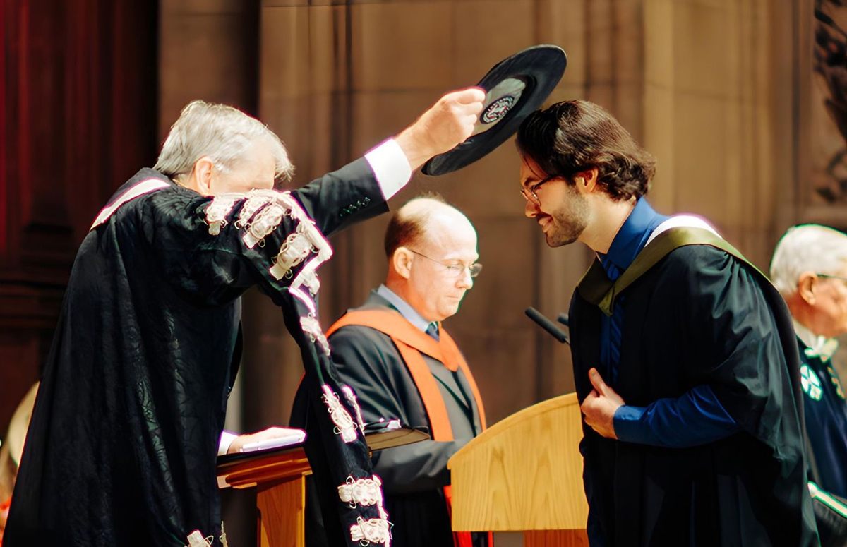 En la ceremonia de graduación de la Universidad de Edimburgo, un estudiante recibe el Gorro de Ginebra.