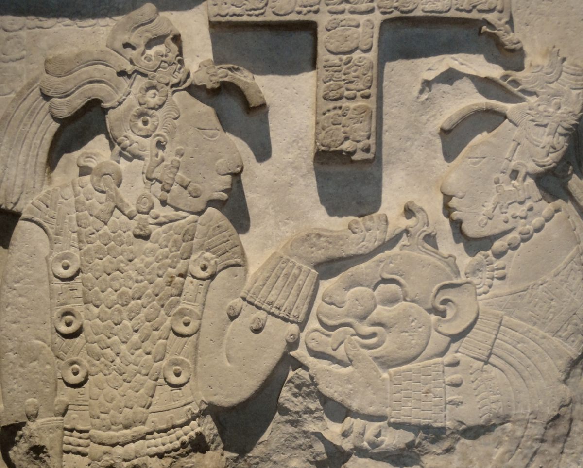 Un detalle del Dintel 26 del sitio maya de Yaxchilán muestra a la reina sosteniendo un casco ceremonial para dárselo al rey.