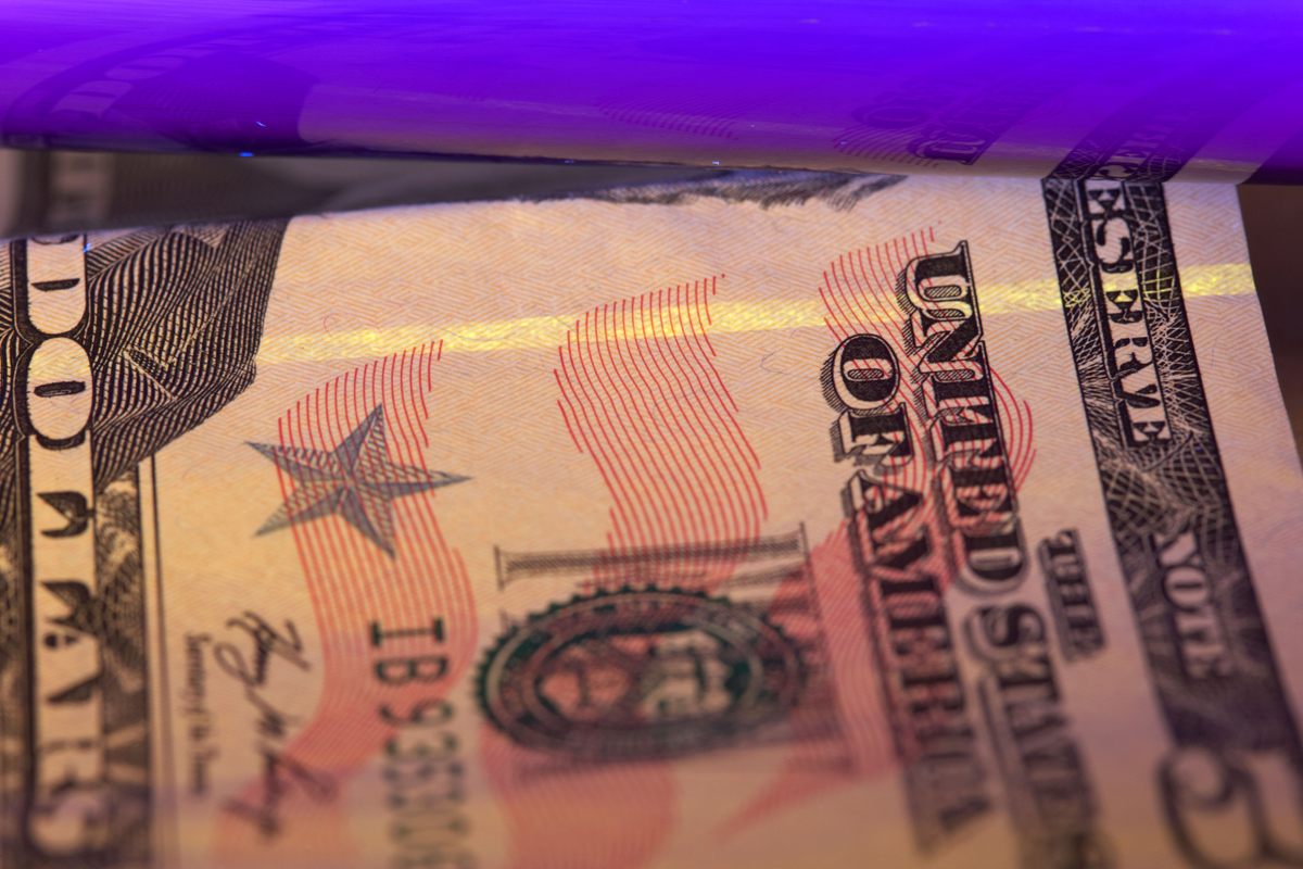 Una luz negra ultravioleta verifica que un billete de $50 sea auténtico.