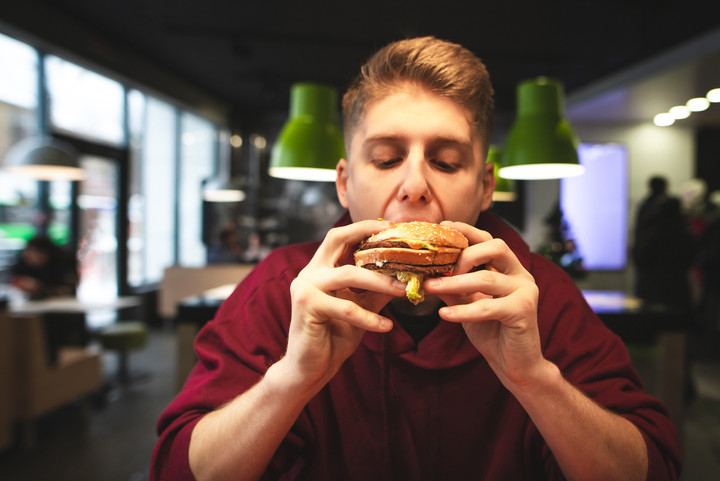 Adolescente comiendo comida chatarra. Foto: Shutterstock