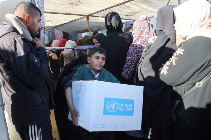 Un chico palestino lleva una caja con ayuda humanitaria proporcionada por la agencia de la ONU para los refugiados (UNRWA), en Jan Younis. Foto: REUTERS 