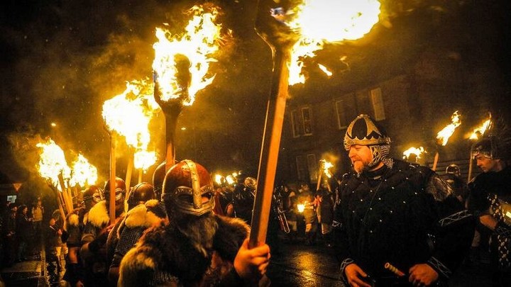 Los participantes marchan entre el fuego con sus llamativos disfraces.
Foto: AFP.