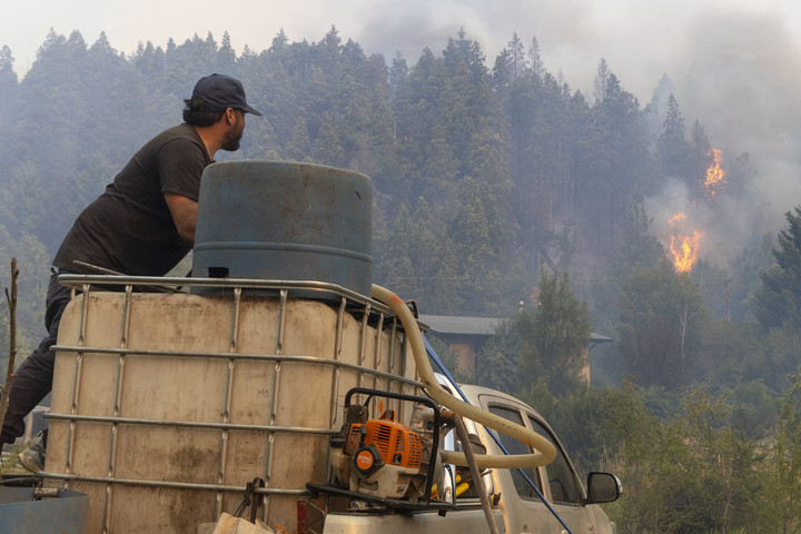 Los vecinos convirtieron sus camionetas en pequeñas autobombas para combatir el incendio. Foto: Euge Neme