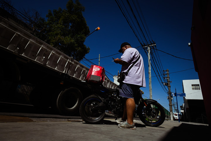 Diego, observando la aplicación de PedidosYa. Le robaron su moto el miércoles y sus amigos se la recuperaron. 
Foto Mariana Nedelcu