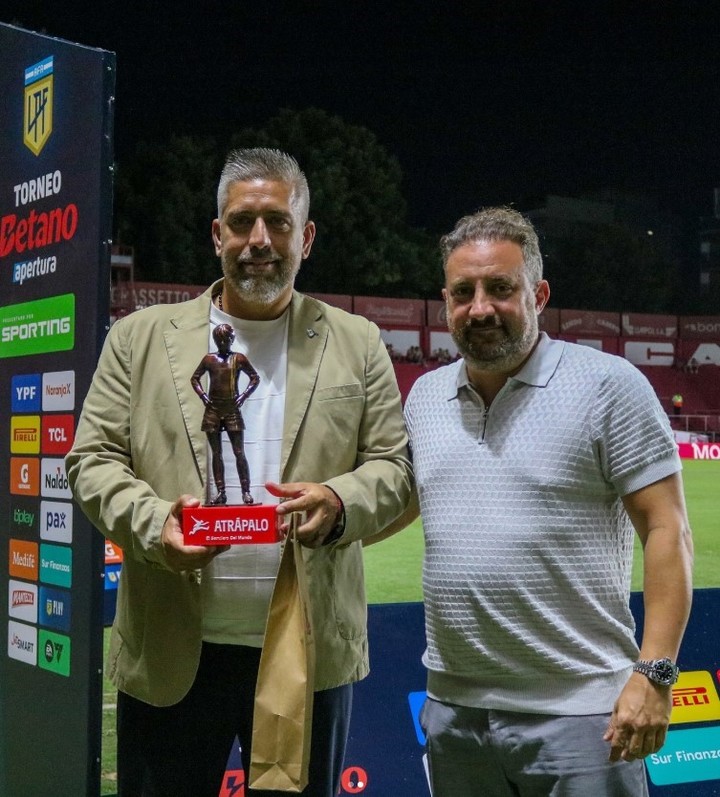 Cristian Malaspina entregando un "Cebollita" a Sebastián Ordoñez, presidente de Platense, durante la fecha número 3 del Apertura.