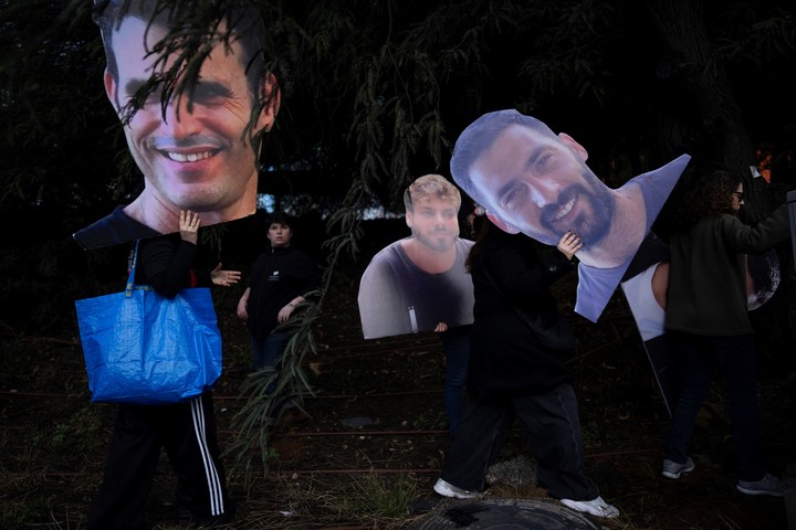 Activistas sostienen fotos con los rostros de los rehenes israelíes retenidos en la Franja de Gaza, durante una protesta para exigir su liberación del cautiverio de Hamás, en Tel Aviv, Israel, jueves 13 de febrero de 2025. (AP Photo/Oded Balilty)