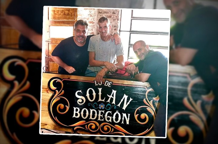 El actor Maxi Ghione junto al cartel de su bodegón, Lo de Solan. Foto: Instagram @lodesolan.