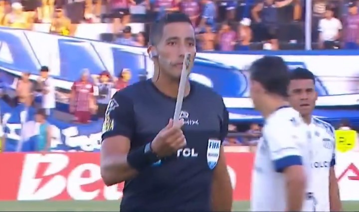 El árbitro Yael Falcón Pérez muestra el palo con el que agredieron al juez de línea desde la hinchada de Godoy Cruz, en el partido ante Talleres de Córdoba por la Liga Profesional.