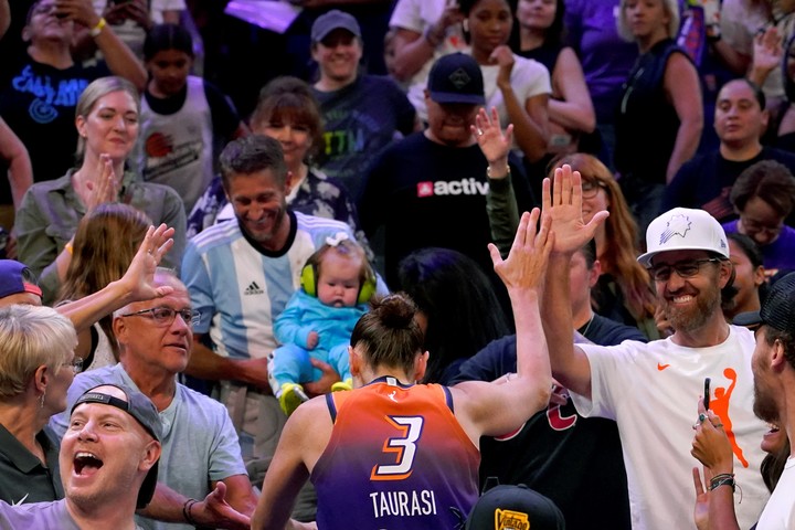 Diana, el 3 de agosto de 2023, al superar la marca de los 10.000 puntos en la WNBA, jugando para Phoenix; en la tribuna, su familia con los colores argentinos. 
Foto: AP Photo