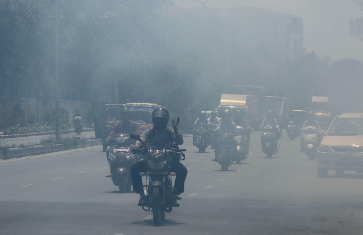 Varios vehículos circulan por una calle en Bangalore (India) una de las urbes del mundo que registra mayores niveles de contaminación del aire (EFE).