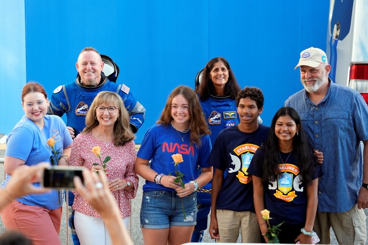 Los dos astronautas atrapados, atrás, con sus familias. Foto: AP