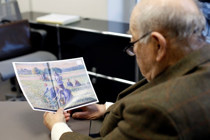 En esta foto de archivo del martes 7 de noviembre de 2017, Jean-Jacques Bauer, mira una reproducción de un valioso cuadro de Pissarro que recuperó, durante una entrevista con Associated Press, en París, Francia. Un tribunal de apelaciones de París ha confirmado una sentencia que ordenaba a una pareja estadounidense devolver un cuadro de Camille Pissarro a los descendientes de una familia judía que era propietaria de la obra de arte cuando fue incautada durante la Segunda Guerra Mundial. (AP Photo/Thibault Camus, File) 