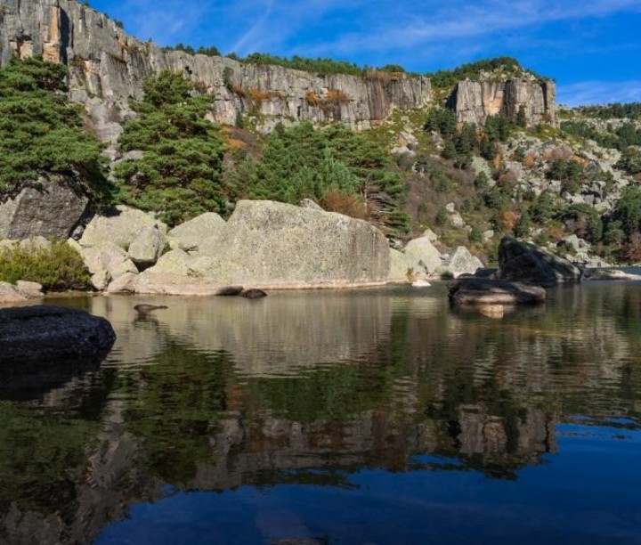 la laguna a casi 2.000 metros de altura, rodeada por pinares y altas paredes graníticas.