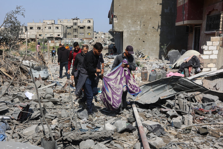 Un grupo de palestinos lleva un cuerpo hallado bajo los escombros tras un ataque aéreo israelí en Ciudad de Gaza. Foto: AFP 