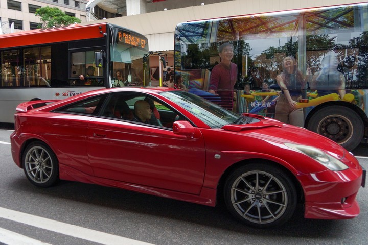 Un coche y autobuses comparten una calle en Singapur, el 11 de marzo de 2025. El precio de los permisos, que se introdujeron en Singapur en 1990 para limitar la contaminación y la congestión, aumenta con el valor del coche. (Chang W. Lee/The New York Times)