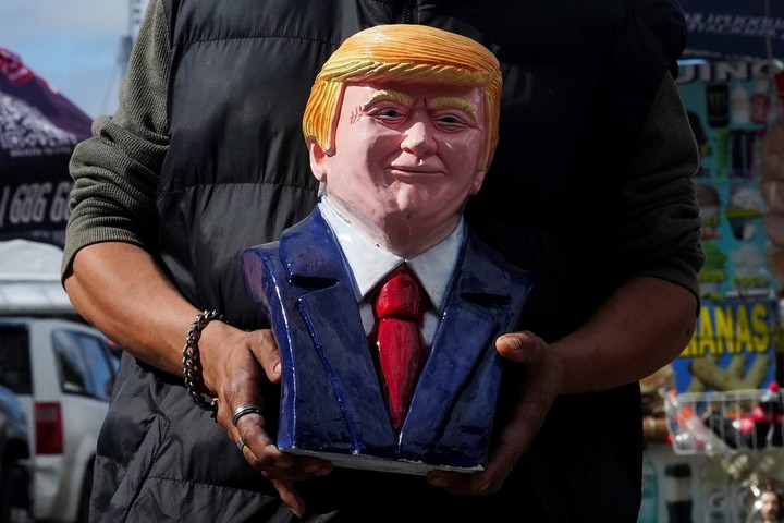 Un vendedor sostiene un busto del presidente de Estados Unidos, Donald Trump, en el cruce fronterizo de San Ysidro, en Tijuana, México, el 12 de marzo de 2025. REUTERS/Aimee Melo