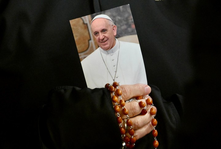 Una monja reza con un rosario y una foto del Papa Francisco, en la Plaza San Pedro, en el Vaticano. Foto: EFE  