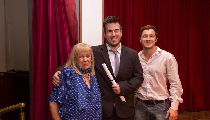 Facundo posó con su título de contador, junto a su mamá y un amigo, durante la colación en la Universidad Nacional del Sur.