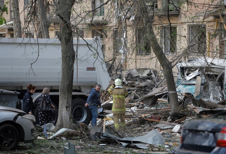 Vecinos y socorristas intentan llegar a las viviendas destrozadas en Kiev. Foto: EFE