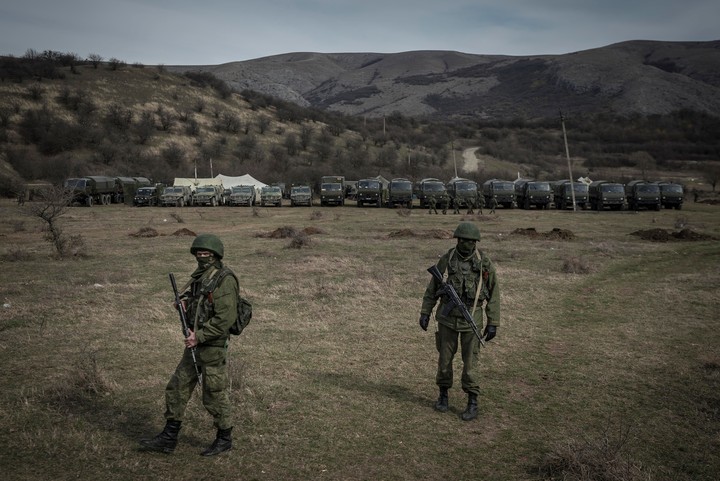 Soldados rusos enmascarados vigilando una base militar ucraniana en Perevalnoe, Crimea, en 2014. Foto Sergey Ponomarev para The New York Times