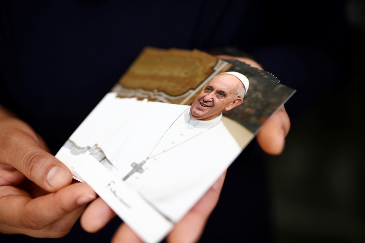 Una persona muestra imágenes del Papa Francisco. Foto: EFE