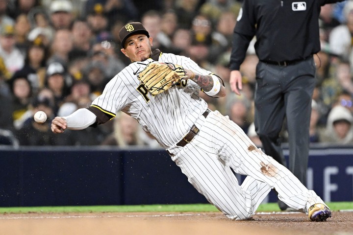San Diego Padres tercera base Manny Machado (13) lanza a primera de rodillas, pero es incapaz de conseguir el out en Cleveland Guardians tercera base Gabriel Arias (13) durante la quinta entrada en el Petco Park. Foto Denis Poroy-Imagn Images