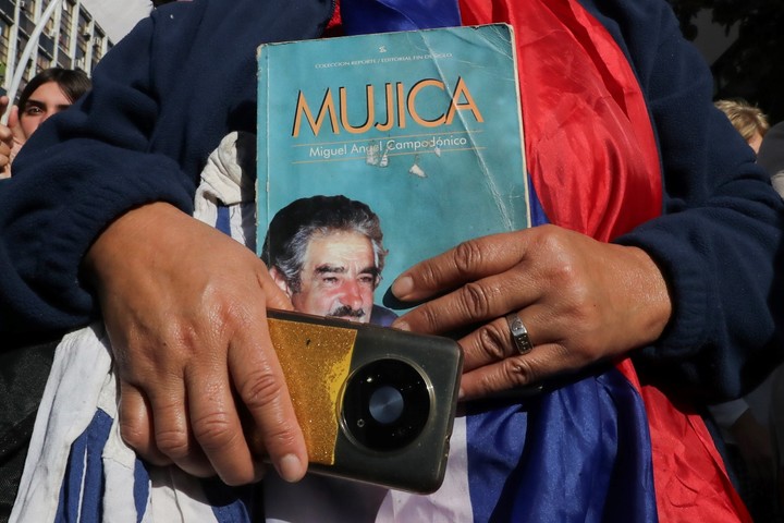 Una persona sostiene un libro durante el cortejo fúnebre del expresidente uruguayo José Mujica este miércoles. EFE/ Raúl Martínez