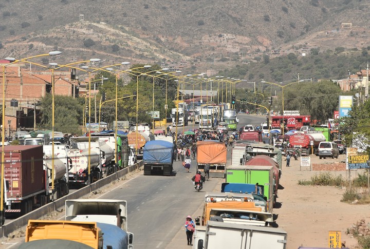 Camiones esperan en una carretera tras un bloqueo realizado por seguidores del exmandatario Evo Morales en Cochabamba. Foto EFE