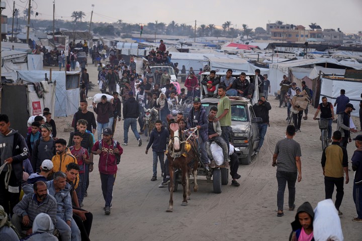 Palestinos marchan con bolsas de alimentos y ayuda humanitaria en Gaza. Foto: AP