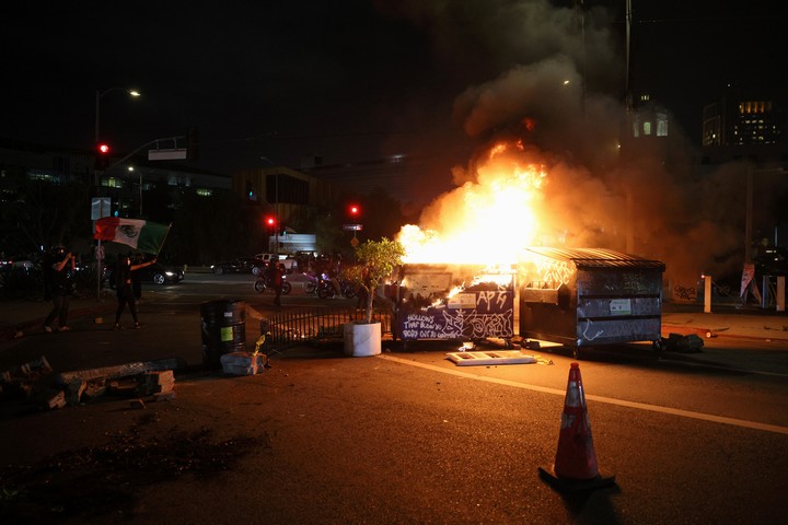 Un tacho de basura se incendia en medio de los incidentes. Foto: EFE 