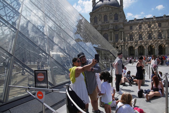 Los turistas esperan en fila fuera del museo del Louvre, que no abrió a tiempo el lunes 16 de junio de 2025 en París. (Foto AP/Christophe Ena)