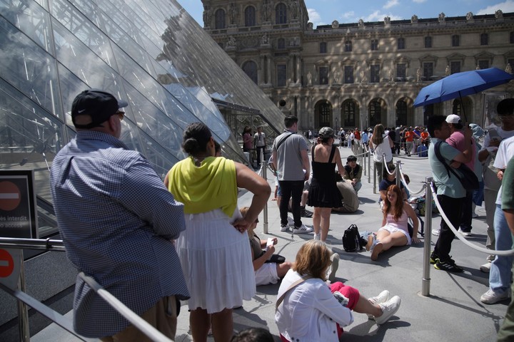 Los turistas esperan en fila fuera del museo del Louvre, que no abrió a tiempo el lunes 16 de junio de 2025 en París. (Foto AP/Christophe Ena)