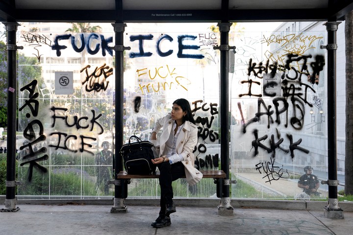 Una persona mira desde un parada de colectivos los enfrentamientos del domingo en Los Ángeles. Foto: Reuters