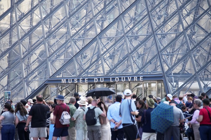 Los turistas esperan en fila fuera del museo del Louvre, que no abrió a tiempo el lunes 16 de junio de 2025 en París. (Foto AP/Christophe Ena)