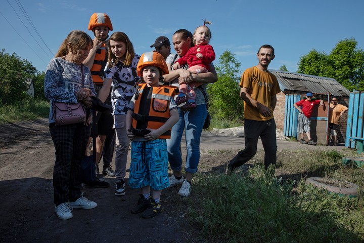 Una familia en la región de Donetsk, con algunos niños protegidos por un equipo de rescate, se prepara para evacuar una zona de primera línea cerca de Toretsk, Ucrania, el 20 de mayo de 2023. Según estimaciones del gobierno, unos 280.000 civiles, incluidos más de 21.000 niños, permanecen en la parte de la región oriental que Ucrania aún controla, y las peticiones de más evacuaciones son constantes. (Tyler Hicks/The New York Times)