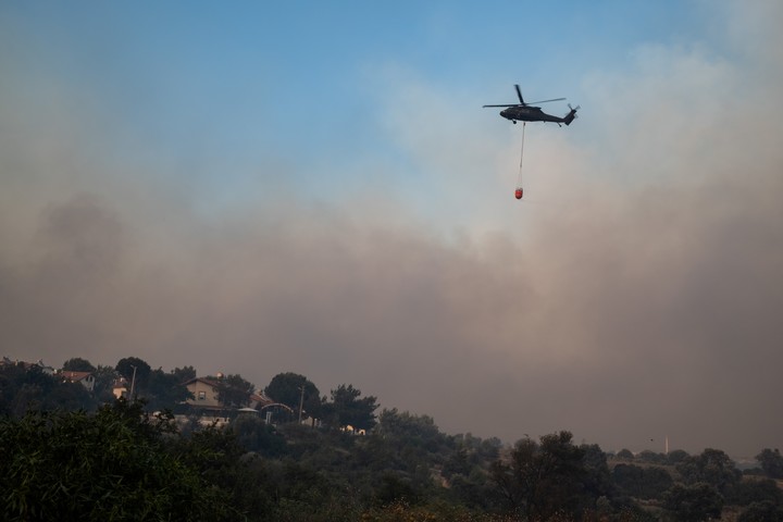 Un helicóptero transporta agua para apagar el fuego durante los incendios forestales de Izmir (Turquía). Foto: EFE