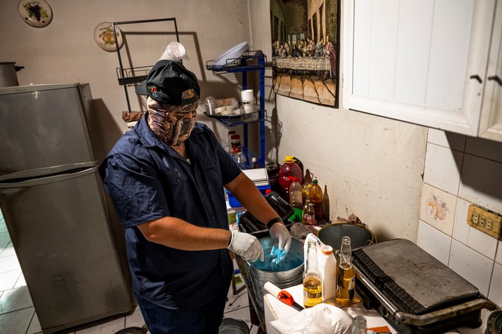 Un cocinero del cártel de Sinaloa mezclando tinte azul en un cubo de polvo de fentanilo. Foto Meridith Kohut para The New York Times.