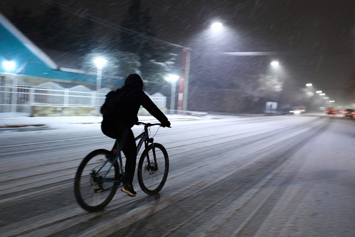 En bici por una calle durante una nevada en 2024 en Maquinchao, Río Negro. Foto EFE/ STR