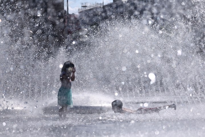 Niños juegan en una fuente en la plaza Karlspatz, en el centro de Múnich, Alemania. Foto EFE