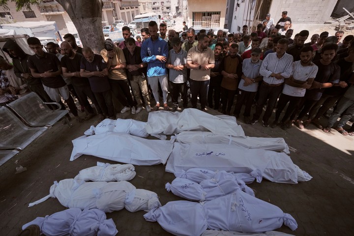 Palestinos junto a los cuerpos, víctimas de los bombardeos de este jueves en Gaza. Foto: AP