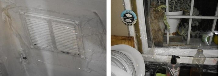 Una rejilla de ventilación y el marco de una ventana de la casa de Villa Devoto tapados con cinta y papel film.