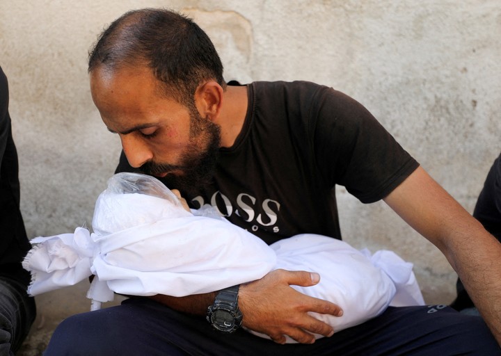 Un hombre besa el cupero de un bebé palestino muertos en los ataques israelíes. Foto: Reuters