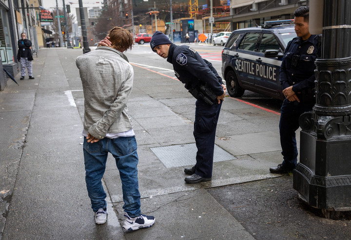 Policia de Seattle trata de ayudar a un hombre en situacion de calle que fumo fentanilo.Foto MOORE / GETTY IMAGES NORTH AMERICA via AFP.