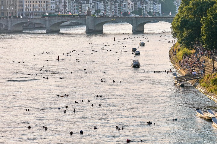 Cientos de personas navegan por el río Rin al anochecer durante una ola de calor en el centro de Basilea, Suiza. Foto AP