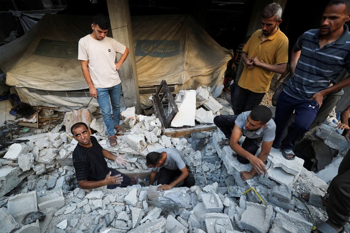 Palestinos buscan víctimas en el lugar de un ataque israelí nocturno contra una casa, en la ciudad de Gaza. Foto Reuters